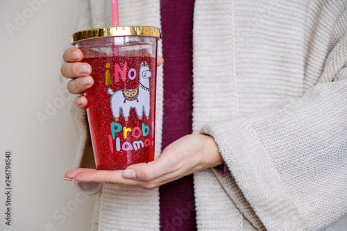 Fresh juice in a bottle with printed lama in womans hands © natus111