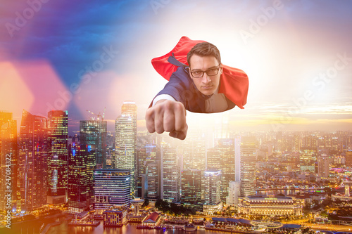 Superhero businessman flying over the city