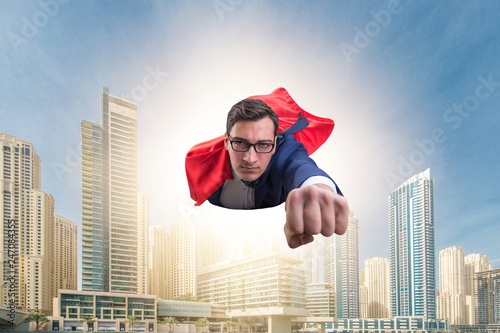 Superhero businessman flying over the city