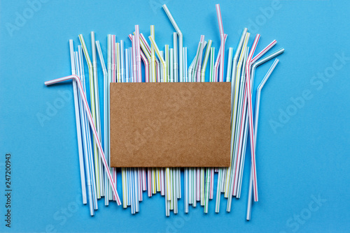 Colored drinking straw on a blue background. Disposable plastic straws are harmful to the environment. Mockup template © sherlesi 
