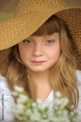 Girl in a straw hat with a bouquet of flowers. Hands, children. © Evdoha
