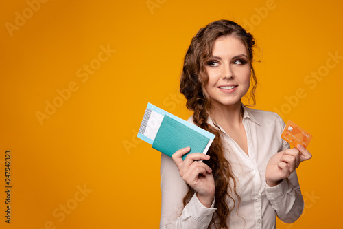 Pretty smiling woman buying tickets online by credit card, buying tickets online to fly by plane © burdun