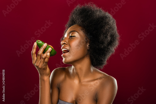 Beautiful afro American woman eating an avocado © zinkevych