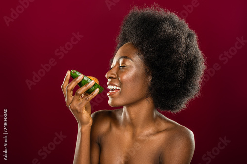 Delighted cheerful woman looking at the avocado © zinkevych