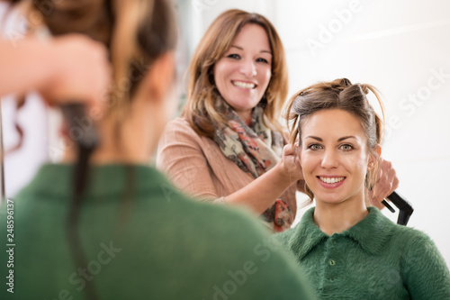 Smiling happy faces of a hairstylist and client © photology1971