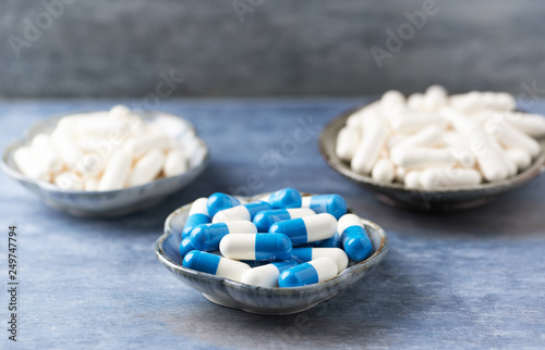 Creatine, Beta-alanine and Taurine capsules. Bodybuilding food supplements on rustic wooden background. Close up. Copy space. © Eugeniusz Dudziński