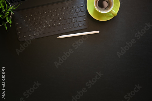 Office dark leather desk table with coffee, computer and office supplies. © bongkarn
