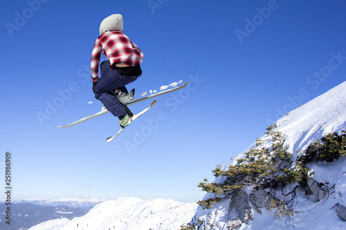 Flying skier at jump inhigh on snowy mountains © smuki