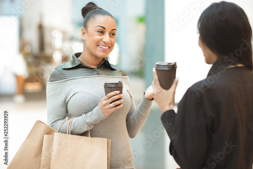 Two African American female friends having coffee and shopping together