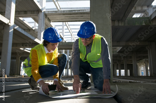 Two young architect going through construction plan details