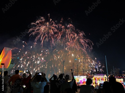The crowd celebrates the Chinese New Year in Singapore. Silhouettes of people watching a fireworks display. Stock photo. © Krzysztof
