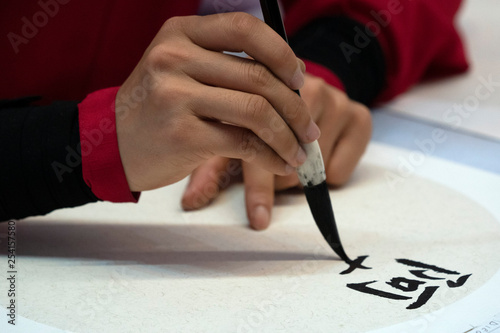 japanese woman writing ideograms with brush © Andrea Izzotti