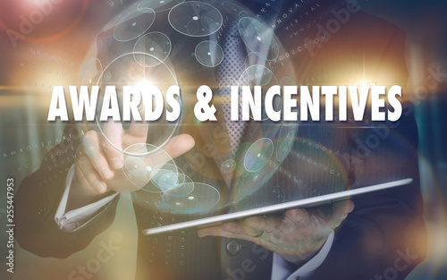 A hand selecting a Awards and Incentives business concept on a futuristic computer display.