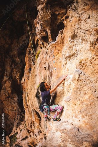 A girl climbs a rock.