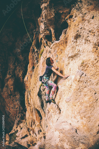 A girl climbs a rock.