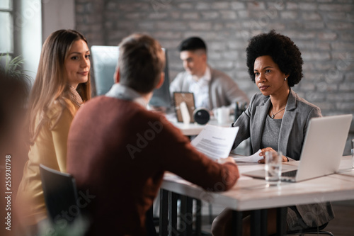 African American insurance agent having a meeting with a couple in the office.