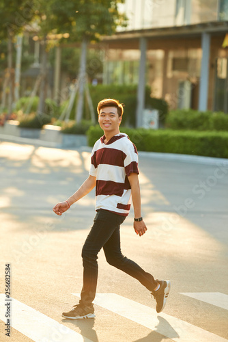 Cheerful man walking outdoors © DragonImages