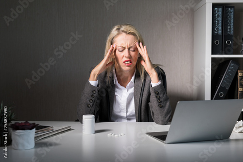Woman feeling headache at work © Kaspars Grinvalds