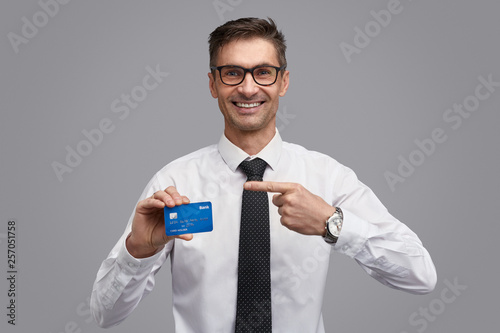 Friendly businessman showing credit card © kegfire