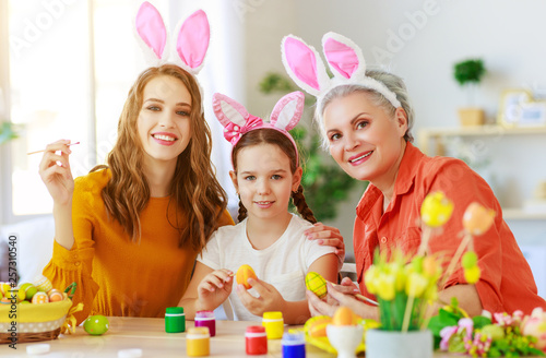 happy Easter! family grandmother, mother and child paint eggs and prepare for holiday. © JenkoAtaman