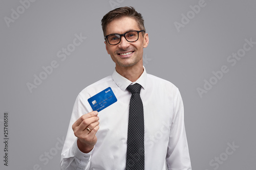 Friendly businessman showing plastic card © kegfire