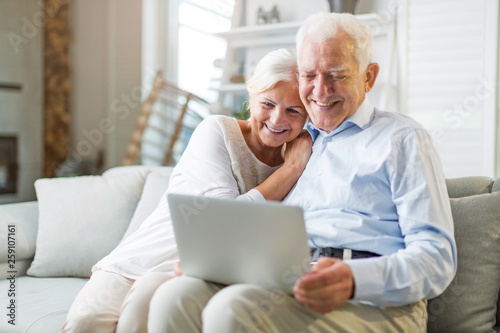 Senior couple using laptop computer at home © pikselstock