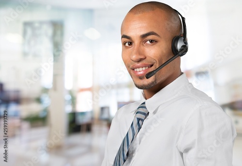 Young male phone service manager on blurred office background © BillionPhotos.com