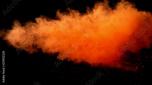 Super slow motion of orange powder explosion isolated on black background. Filmed on high speed cinema camera, 1000fps. © Jag_cz