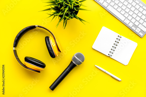 microphone, headphones, notebook and keyboard for blogger, journalist or musician work on yellow background top view copyspace © 9dreamstudio