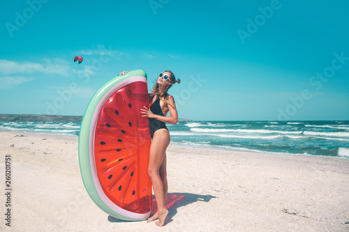 Model with watermelon lilo at the beach © Alena Ozerova