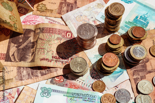 Stacks of coins on paper notes. Banknotes and coins of different countries.