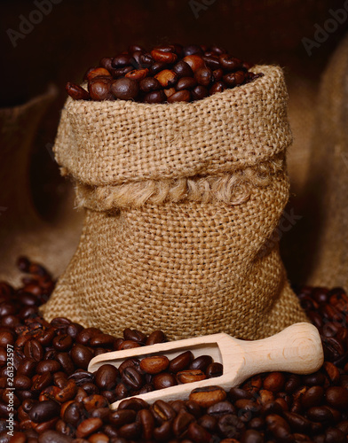 Coffee beans in a wooden scoop and bag. © Galyna