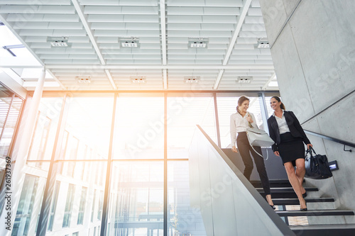 Business Frauen reden auf Treppe miteinander © Robert Kneschke