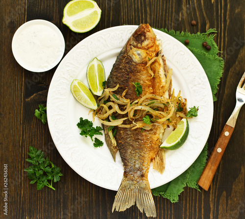 Fried carp with onions and white sauce. © ld1976