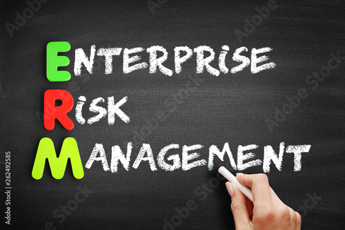 Color Wooden alphabets building the word ERM - Enterprise Risk Management acronym on blackboard © dizain