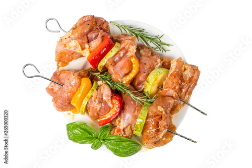 skewers of raw meat and vegetables in marinade on the plate isolated on white background. top view © samael334