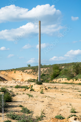 old electrical post in the middle of sand quarry